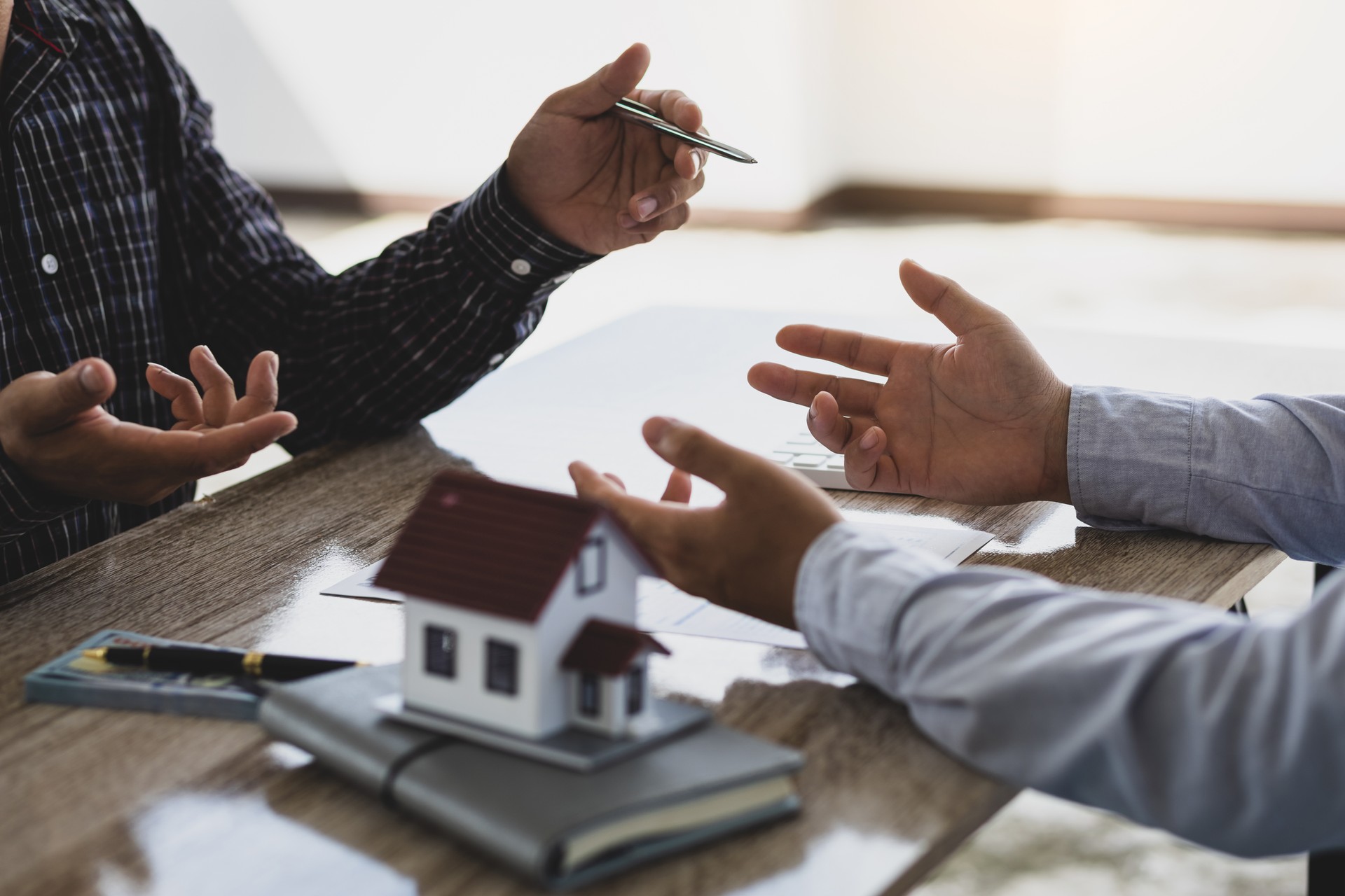 Real estate agents discuss home and land purchases with customers after agreeing to a home purchase and loan agreement.